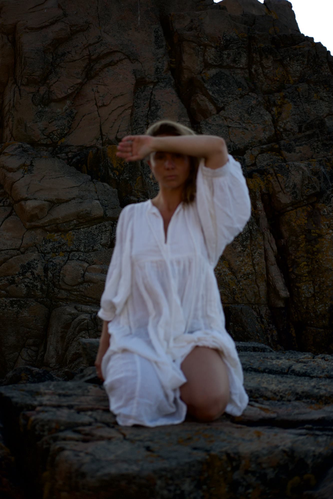 Amanda Roth sitting among rocks by the water